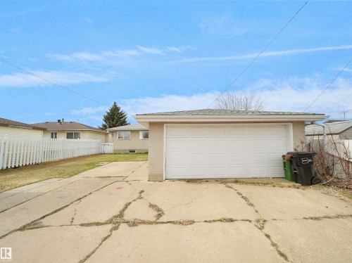 Detached garage with a paneled overhead door, stucco exterior, and a shingled roof - 8703 73 Street, Edmonton, AB - Outdoor With Exterior