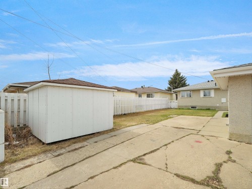 Detached shed featuring white siding and a brown shingle roof - 8703 73 Street, Edmonton, AB - Outdoor