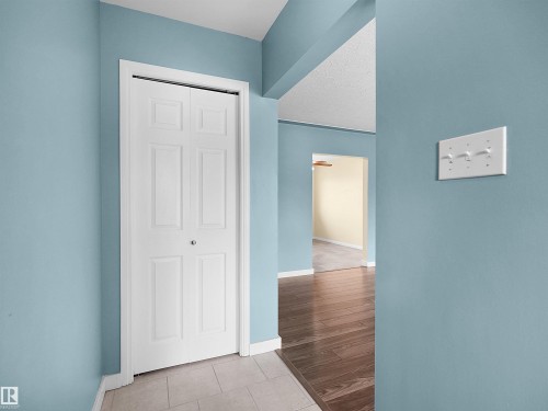 Entryway featuring a white bi-fold door, light blue walls, and tile flooring - 8703 73 Street, Edmonton, AB - Indoor