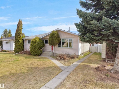 Ranch-style residence featuring light-colored siding and a contrasting red entry door - 8703 73 Street, Edmonton, AB - Outdoor