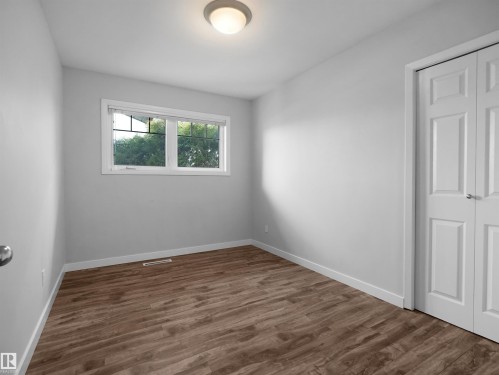 Room featuring wood-finish flooring, light grey walls, and a white trim package - 8703 73 Street, Edmonton, AB - Indoor Photo Showing Other Room