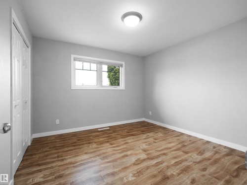 Room featuring wood-finish flooring, light gray wall paint, and white trim - 8703 73 Street, Edmonton, AB - Indoor Photo Showing Other Room