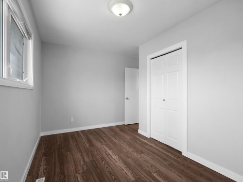 Neutral gray walls with dark wood-finish flooring - 8703 73 Street, Edmonton, AB - Indoor Photo Showing Other Room