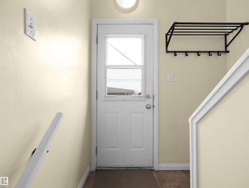 Entryway featuring a white paneled door with window inserts, neutral wall color, and wood-finish flooring - 8703 73 Street, Edmonton, AB - Indoor Photo Showing Other Room