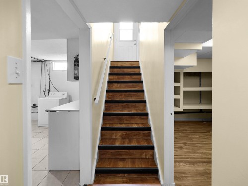 Wood-finish stairs with white risers and handrail - 8703 73 Street, Edmonton, AB - Indoor Photo Showing Other Room
