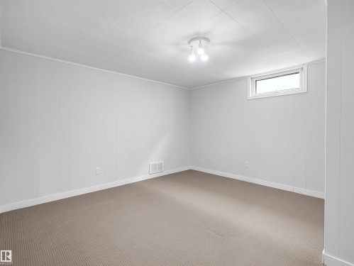 Carpeted room with a drop ceiling, white paneled walls, and a recessed window - 8703 73 Street, Edmonton, AB - Indoor Photo Showing Other Room