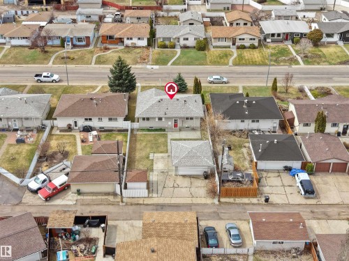Single-story residence featuring a gray asphalt shingle roof and a red front door - 8703 73 Street, Edmonton, AB - Outdoor With View