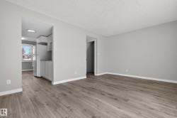 Living area featuring wood-finish flooring, light gray wall paint, and white baseboards - 
