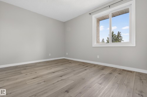 Room featuring light gray walls, white trim, and wood-finish flooring - 18 Lakewood Village, Edmonton, AB - Indoor Photo Showing Other Room
