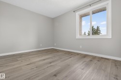 Room featuring light gray walls, white trim, and wood-finish flooring - 