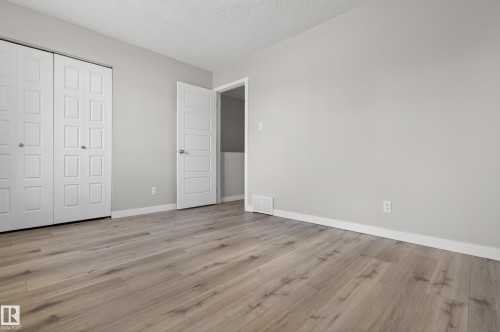 Room featuring light wood-finish flooring, light grey walls, and white baseboards - 18 Lakewood Village, Edmonton, AB - Indoor Photo Showing Other Room