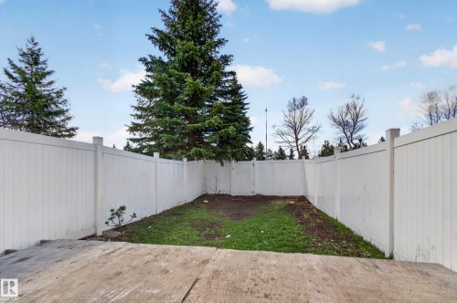 Private backyard featuring a concrete patio, fenced perimeter, and established trees - 18 Lakewood Village, Edmonton, AB - Outdoor