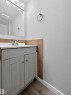 Contemporary bathroom vanity with a light wood-finish cabinet, white countertop, and brushed nickel faucet - 18 Lakewood Village, Edmonton, AB  - Indoor Photo Showing Bathroom 