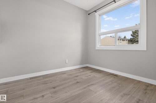 Room featuring light gray walls, white baseboards, and wood-finish flooring - 18 Lakewood Village, Edmonton, AB - Indoor Photo Showing Other Room