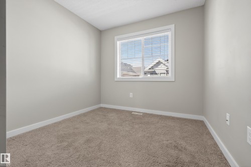 Neutral paint palette with a single window, white trim, and light brown carpeting - 61 2803 James Mowatt Trail, Edmonton, AB - Indoor Photo Showing Other Room