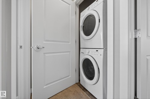 White stackable washer and dryer units - 61 2803 James Mowatt Trail, Edmonton, AB - Indoor Photo Showing Laundry Room