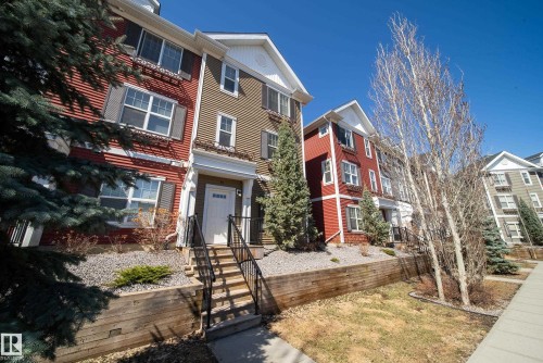Multi-level townhouse exterior featuring red and olive siding with white trim - 61 2803 James Mowatt Trail, Edmonton, AB - Outdoor With Facade