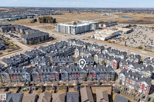 Aerial perspective showcasing a community of multi-story townhomes with varying exterior colors and dormer windows - 61 2803 James Mowatt Trail, Edmonton, AB - Outdoor With View
