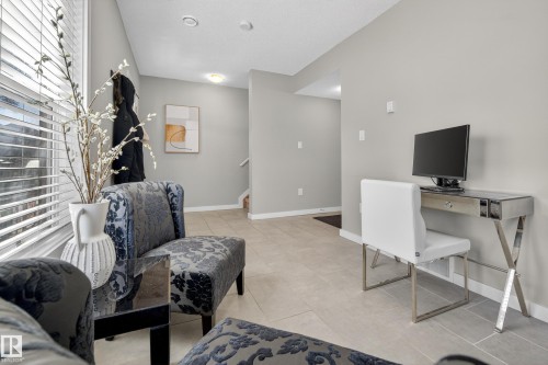 Entry foyer featuring light tile flooring, neutral wall tones, recessed lighting, and a staircase - 61 2803 James Mowatt Trail, Edmonton, AB - Indoor Photo Showing Other Room