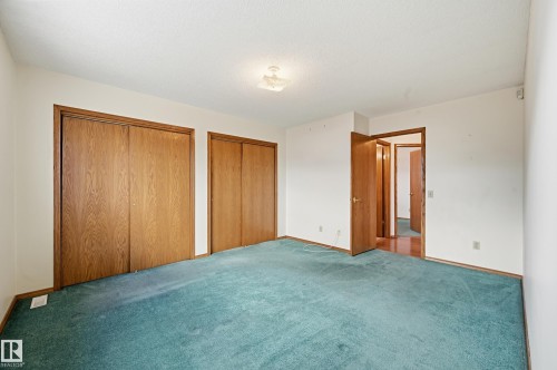 Room featuring teal carpeting, white walls, and a white textured ceiling - 1242 Joyce Crescent, Edmonton, AB - Indoor Photo Showing Other Room