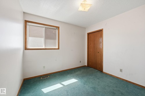 Interior room featuring a single window with blinds, wood-finish trim, and green carpeting - 1242 Joyce Crescent, Edmonton, AB - Indoor Photo Showing Other Room