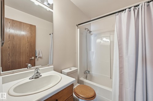 Bathroom featuring a white vanity with an integrated sink, chrome faucet, and a large wall-mounted mirror - 1242 Joyce Crescent, Edmonton, AB - Indoor Photo Showing Bathroom