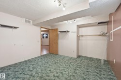 Carpeted room featuring track lighting and an open doorway - 