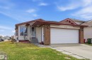 Single-story residence featuring light-colored siding, a two-car garage with white paneling, and a brick facade accent - 1242 Joyce Crescent, Edmonton, AB  - Outdoor With Facade 