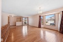 Spacious interior featuring wood-finish flooring, a decorative chandelier, and a large bay window - 1242 Joyce Crescent, Edmonton, AB  - Indoor 