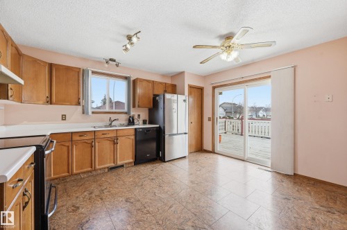 Kitchen featuring wood cabinetry, light countertops, and tile flooring - 1242 Joyce Crescent, Edmonton, AB - Indoor Photo Showing Kitchen With Double Sink