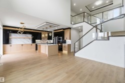 Open-concept living space featuring wood-finish flooring and a contemporary kitchen - 