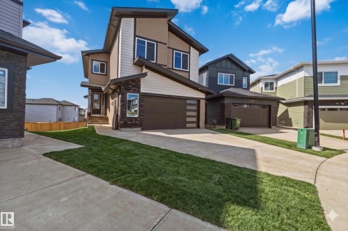 Contemporary two-story residence featuring a multi-textured exterior of siding and stacked stone accents - 417 Pine Point(E), Leduc, AB - Outdoor With Facade