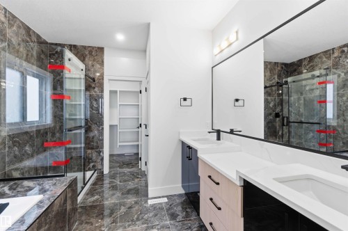 Modern bathroom featuring a dual vanity with white countertops, matte black hardware, and a large frameless mirror - 417 Pine Point(E), Leduc, AB - Indoor Photo Showing Bathroom