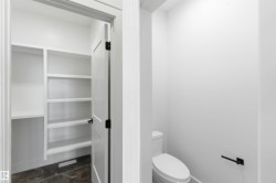 White built-in shelving with multiple levels, featuring a dark floor, and a white interior door with black hardware - 