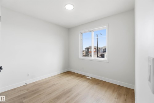 Room featuring light wood-finish flooring, white walls, and bright baseboards - 417 Pine Point(E), Leduc, AB - Indoor Photo Showing Other Room