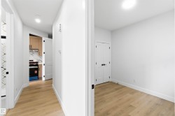 Hallway featuring wood-finish flooring and white baseboards - 