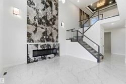 Spacious living area featuring a floor-to-ceiling fireplace with dark stone-finish surround and linear electric insert - 
