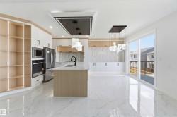 Modern kitchen featuring a central island with a quartz countertop, integrated stainless steel appliances, and wood-finish cabinetry - 
