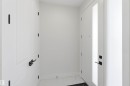 Entryway featuring a white paneled door with matte black hardware, a frosted glass sidelight, and white tile flooring - 415 Pine Point(E), Leduc, AB  - Indoor Photo Showing Other Room 