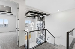 Modern staircase featuring glass panel railings with dark frames, a textured feature wall, and a multi-tiered chandelier - 