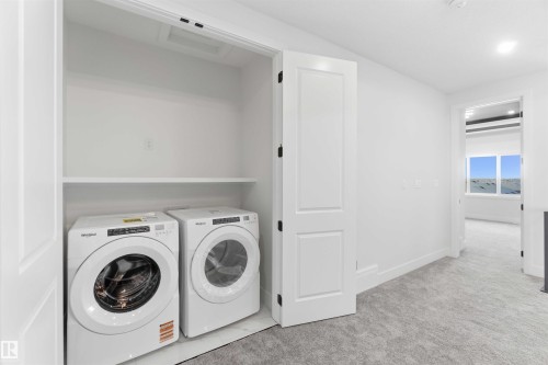 Dedicated laundry closet featuring a built-in shelf and tile flooring - 415 Pine Point(E), Leduc, AB - Indoor Photo Showing Laundry Room