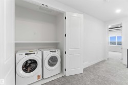 Dedicated laundry closet featuring a built-in shelf and tile flooring - 
