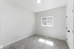 Bright room featuring a window with white trim, gray carpet, white walls, and a flush mount ceiling light - 