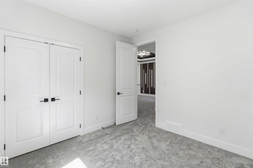 Neutral white walls throughout this space with a plush grey carpet - 415 Pine Point(E), Leduc, AB - Indoor Photo Showing Other Room
