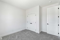 Spacious room featuring neutral carpeting, crisp white walls, and a recessed ceiling light - 