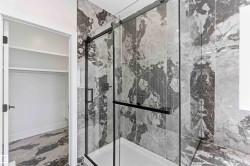 Contemporary tiled shower with a black-framed glass enclosure - 
