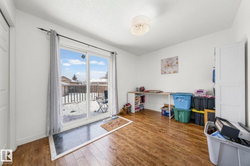 This room features wood-look flooring and white walls, complemented by a contemporary light fixture - 115 Warwick Road, Edmonton, AB - Indoor