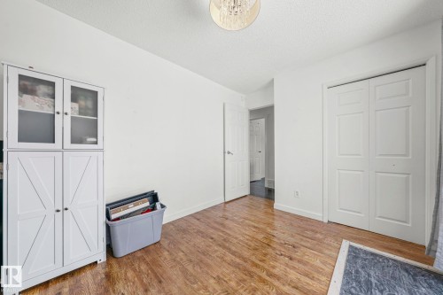 Room featuring wood-look flooring, white walls, and a ceiling light fixture - 115 Warwick Road, Edmonton, AB - Indoor Photo Showing Other Room