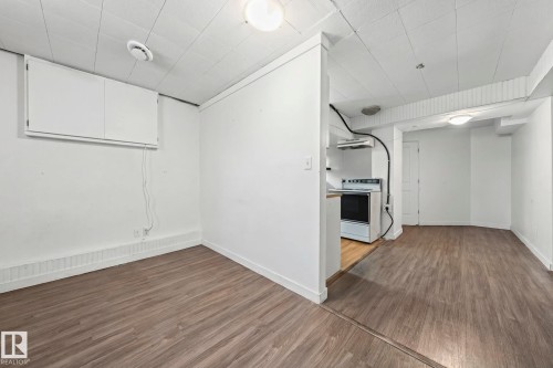 This interior space features wood-style flooring and white walls, offering a versatile foundation - 115 Warwick Road, Edmonton, AB - Indoor