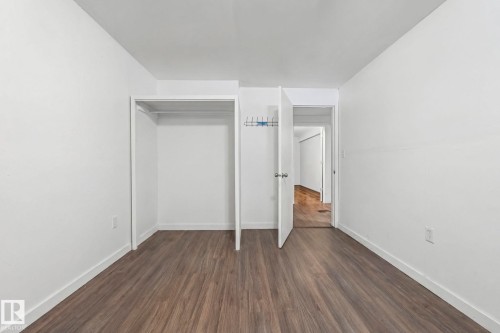 This room features light-toned wood-look flooring and white walls, creating a bright and neutral aesthetic - 115 Warwick Road, Edmonton, AB - Indoor Photo Showing Other Room
